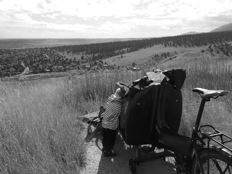 Klara mit Lastenrad auf einem Hügel mit Ausblick, schwarz-weiß